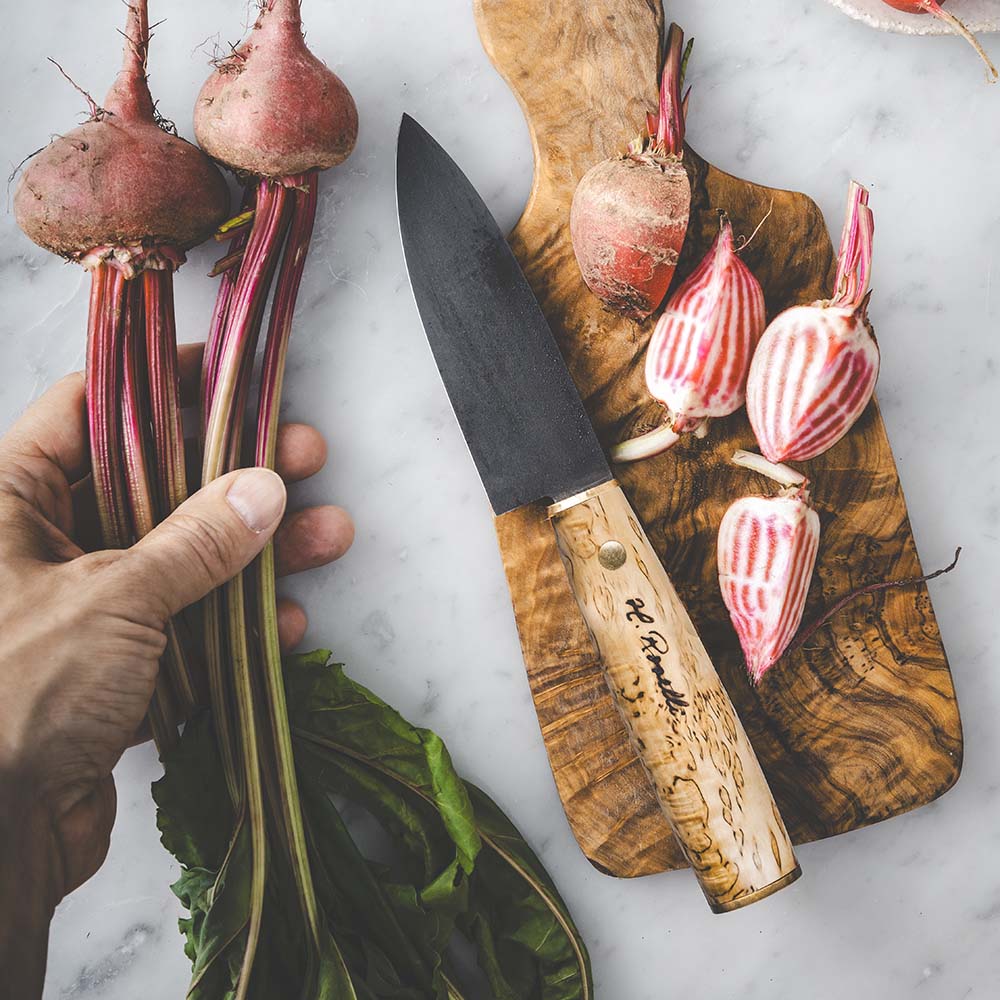 Roselli's Finnish handmade Japanese kitchen knife. Model "Allround knife" with a carbon steel blade and handle made from curly birch. Comes with a handmade sheath of light Finnish vegetable leather.